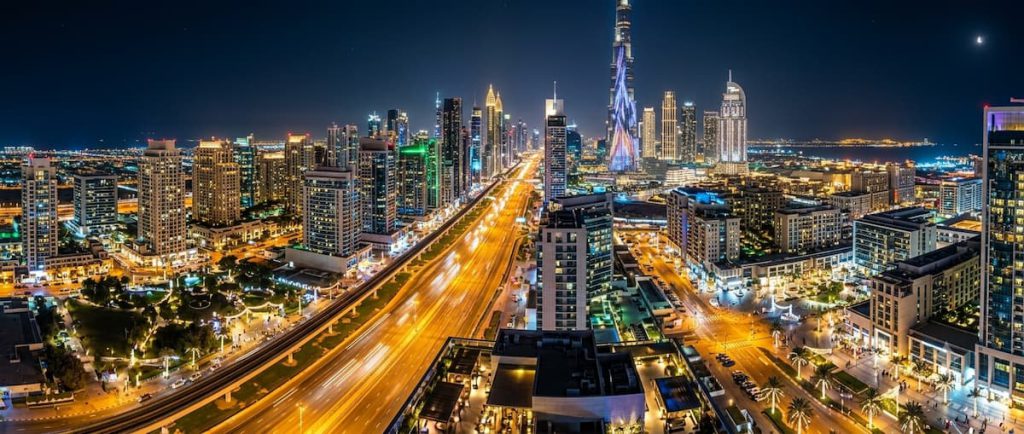 Global Village Dubai: The AED 25 World Tour — Season Dates, Tickets, and How to Do It Right 2 Illuminated streets and buildings across Dubai at night during the winter season