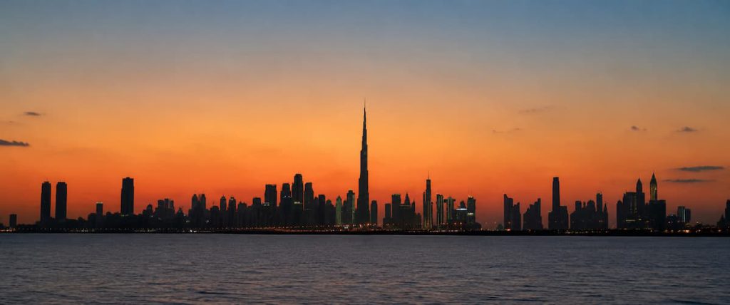 Dubai Visa for Indian Passport Holders: Types, Cost & How to Apply (2026) 2 Dubai skyline silhouette at dusk over the sea