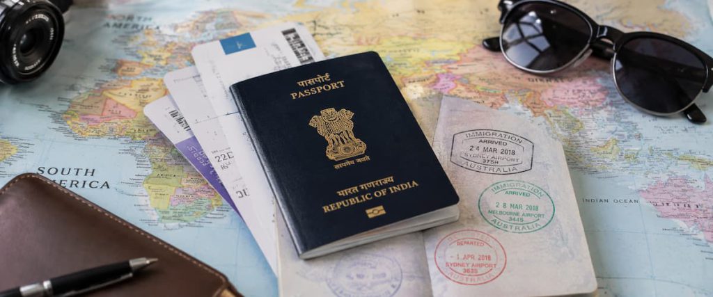 Dubai Visa for Indian Passport Holders: Types, Cost & How to Apply (2026) 1 Passport, travel map and stamps laid out for an international trip